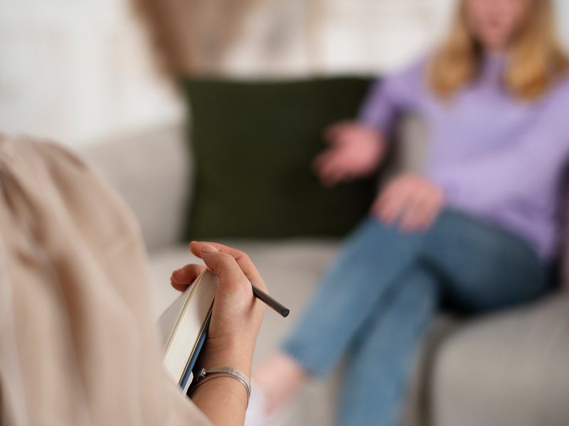 vista-lateral-jovem-conversando-com-terapeuta-compressed